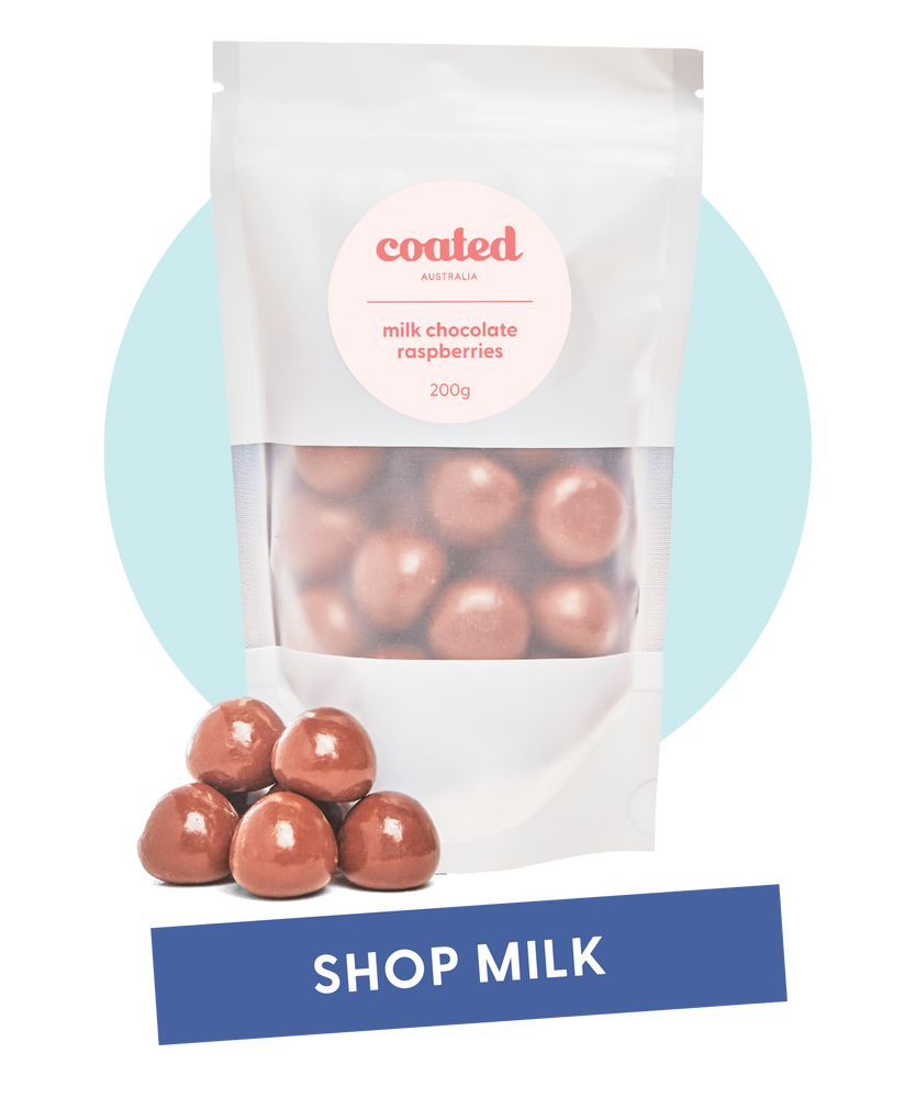 Coated Australia - Shop by Milk Chocolate. Milk Chocolate Coated products. Australian made. Made in Melbourne. Standing white bag, filled with milk chocolate raspberries with a 'shop milk' title.