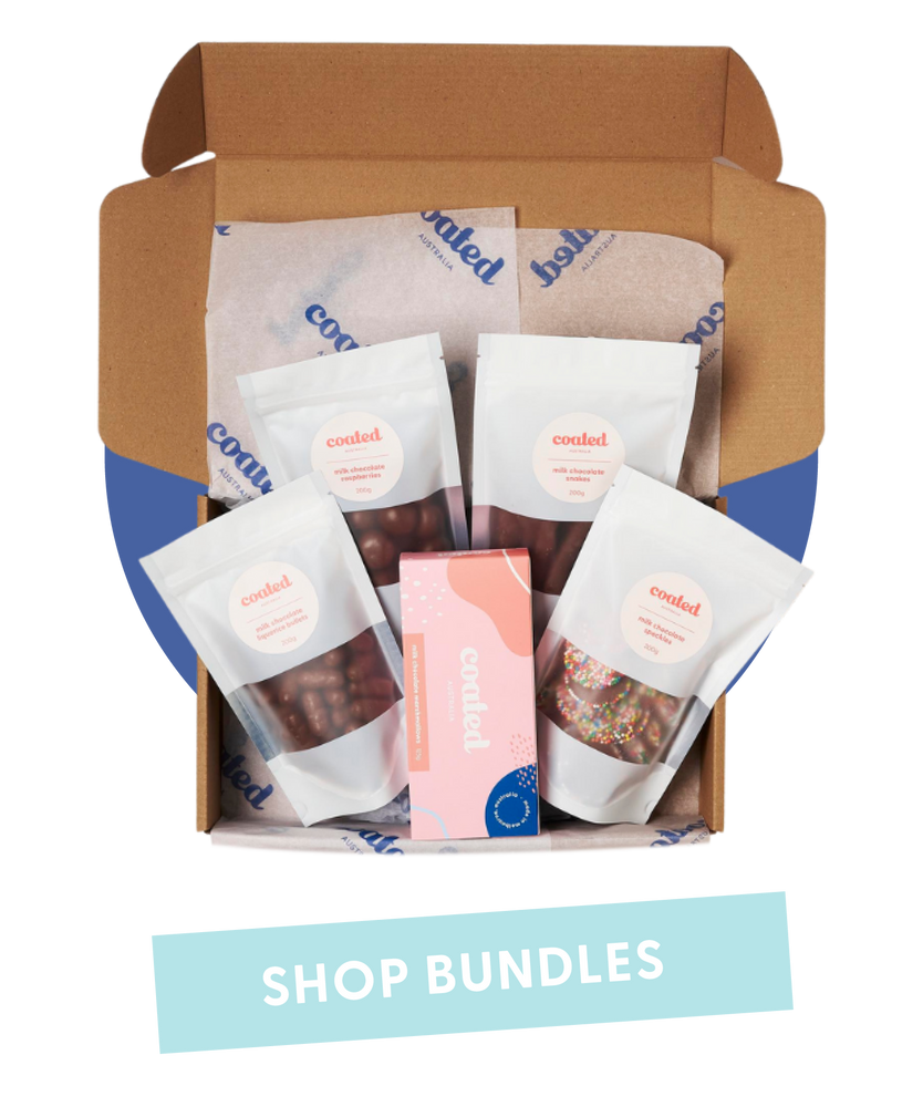 Coated Australia - Shop by Pre Made Gift Boxes and bundles. Chocolate. Chocolate Coated products. Australian made. Made in Melbourne. Open gift box filled with multiple chocolate bags and box of marshmallows with 'shop bundles' title.
